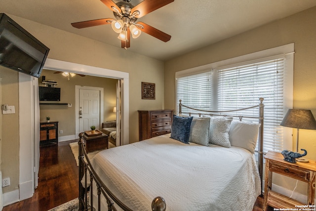 bedroom with dark hardwood / wood-style flooring and ceiling fan