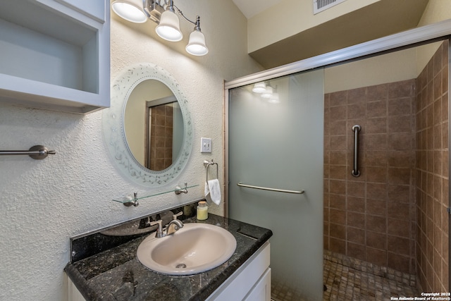 bathroom featuring vanity and a shower with door