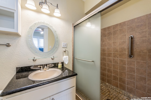 bathroom featuring walk in shower and vanity