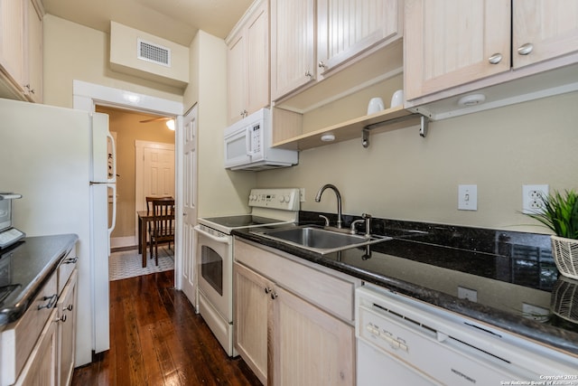 kitchen featuring white appliances, light brown cabinets, dark stone counters, sink, and dark wood-type flooring