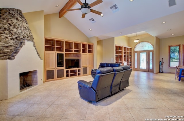 tiled living room with ceiling fan, french doors, a stone fireplace, high vaulted ceiling, and beamed ceiling