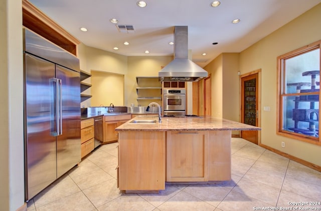 kitchen with island range hood, light brown cabinetry, stainless steel appliances, and sink