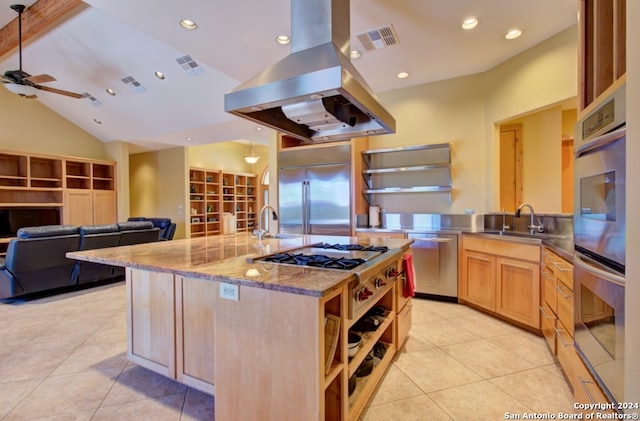 kitchen with island exhaust hood, lofted ceiling, light brown cabinetry, light tile patterned floors, and appliances with stainless steel finishes