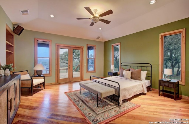 bedroom with light wood-type flooring, french doors, vaulted ceiling, and access to outside