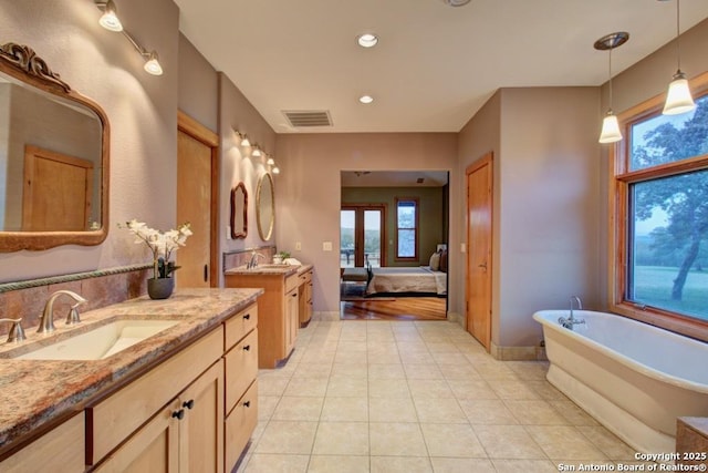 bathroom featuring vanity, tile patterned flooring, and a bathtub