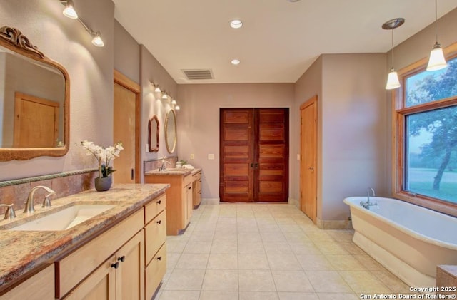 bathroom with vanity, tile patterned flooring, and a bathtub