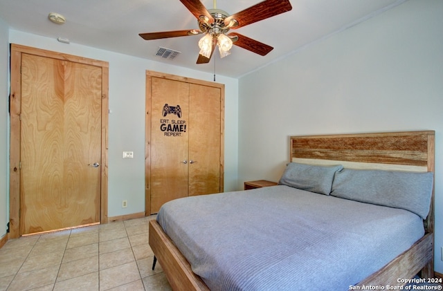 tiled bedroom featuring ceiling fan