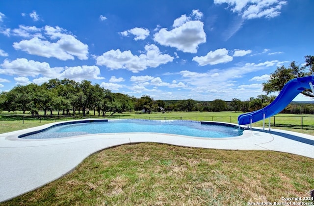 view of pool featuring a lawn and a water slide