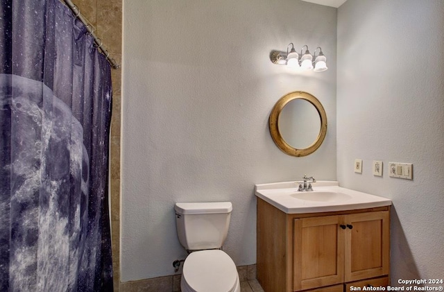 bathroom with toilet, vanity, and curtained shower