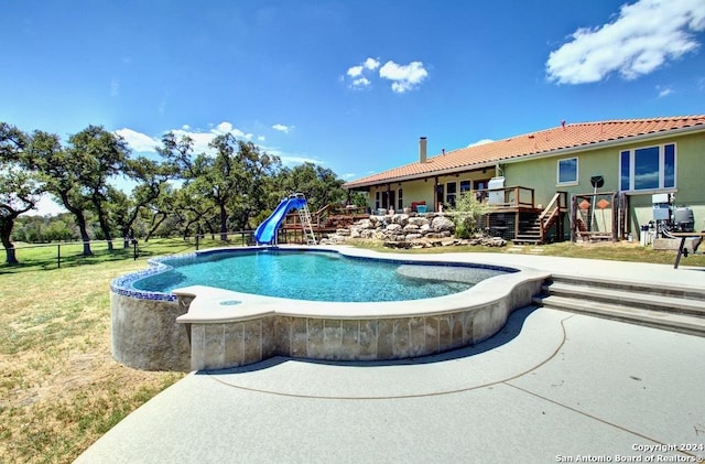 view of pool with a yard, a playground, and a water slide