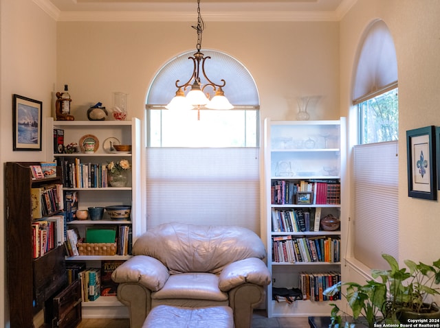 sitting room with crown molding and an inviting chandelier