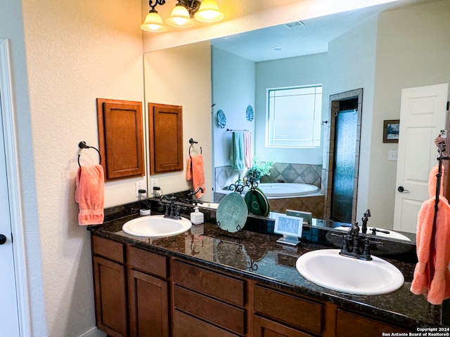 bathroom featuring a tub to relax in and dual vanity