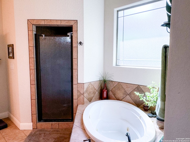 bathroom with plus walk in shower, tile patterned flooring, and a wealth of natural light