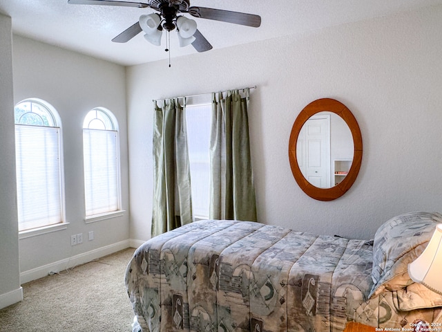 carpeted bedroom featuring ceiling fan and multiple windows