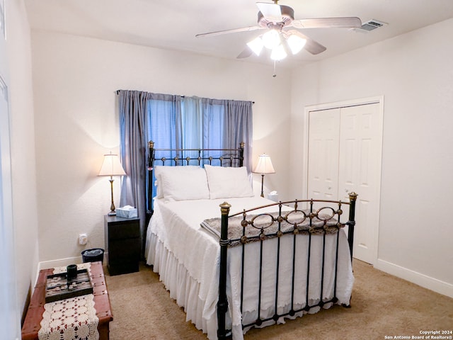 carpeted bedroom featuring ceiling fan and a closet