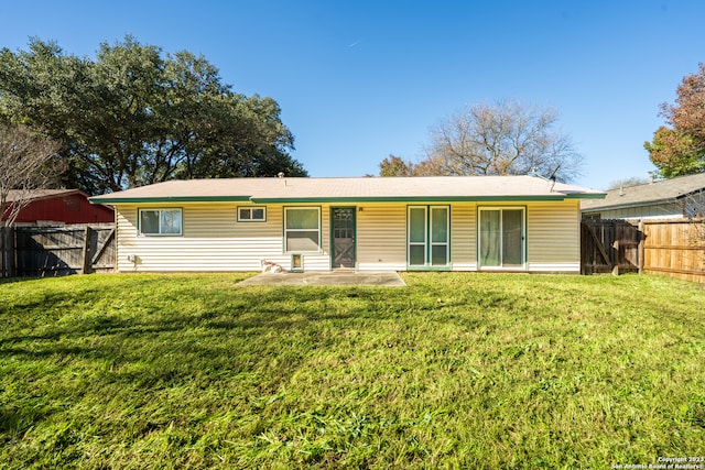 rear view of property with a patio and a yard