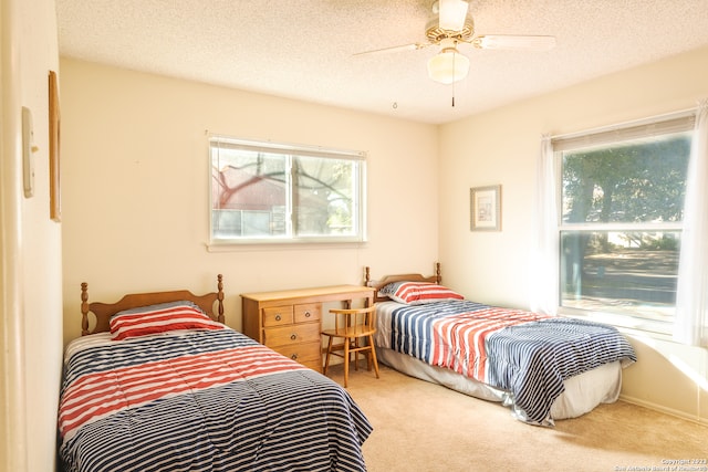 carpeted bedroom featuring ceiling fan and a textured ceiling