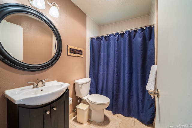 bathroom featuring vanity, a textured ceiling, toilet, and tile patterned flooring