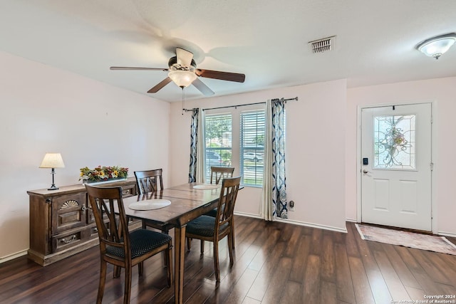 dining area with dark wood-type flooring, visible vents, ceiling fan, and baseboards