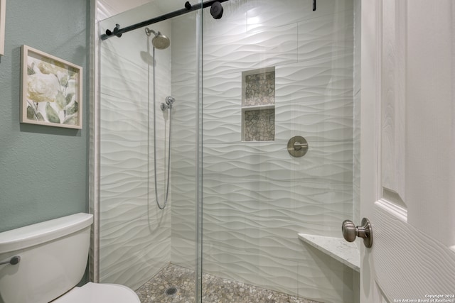 bathroom with a shower with door and toilet