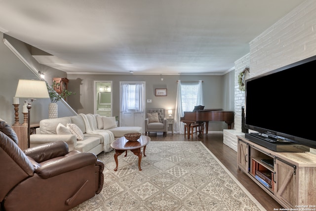 living room with dark wood-type flooring, brick wall, and crown molding