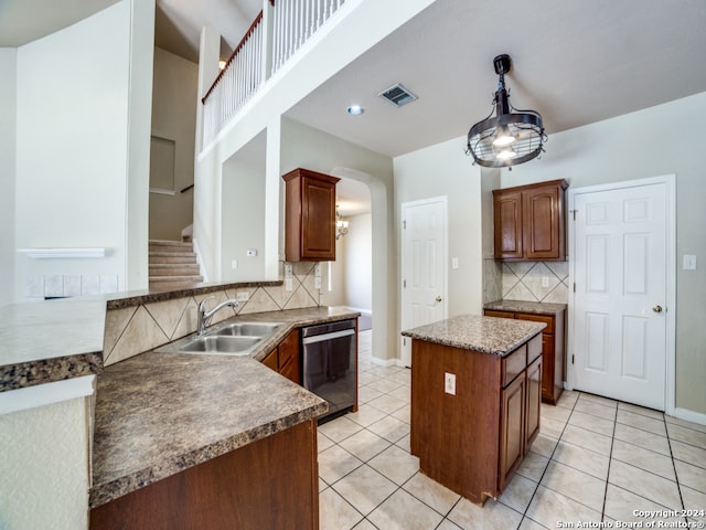 kitchen featuring dishwasher, backsplash, sink, light tile patterned floors, and kitchen peninsula