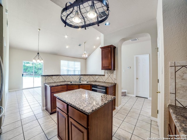 kitchen with ceiling fan, light tile patterned floors, tasteful backsplash, a kitchen island, and stainless steel appliances