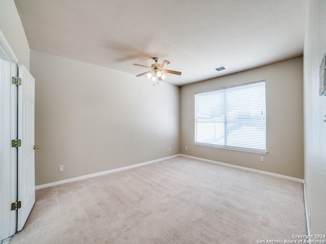 carpeted spare room with ceiling fan