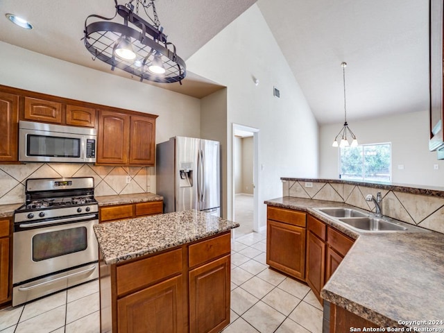 kitchen with pendant lighting, sink, stainless steel appliances, a center island, and light tile patterned flooring