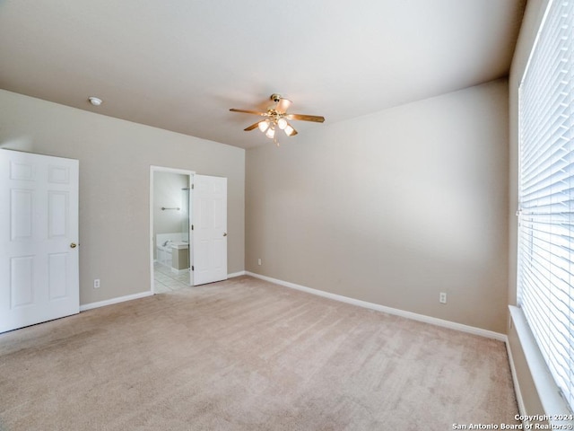 unfurnished bedroom with ceiling fan, light carpet, and ensuite bath