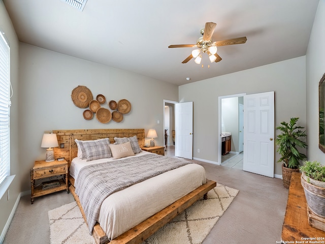 bedroom with light carpet, ceiling fan, and ensuite bathroom