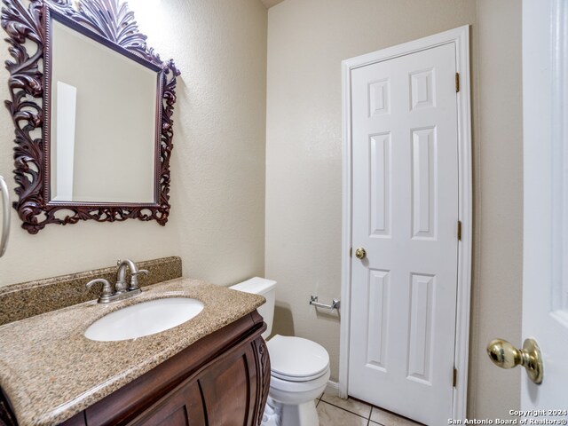 bathroom with tile patterned flooring, vanity, and toilet