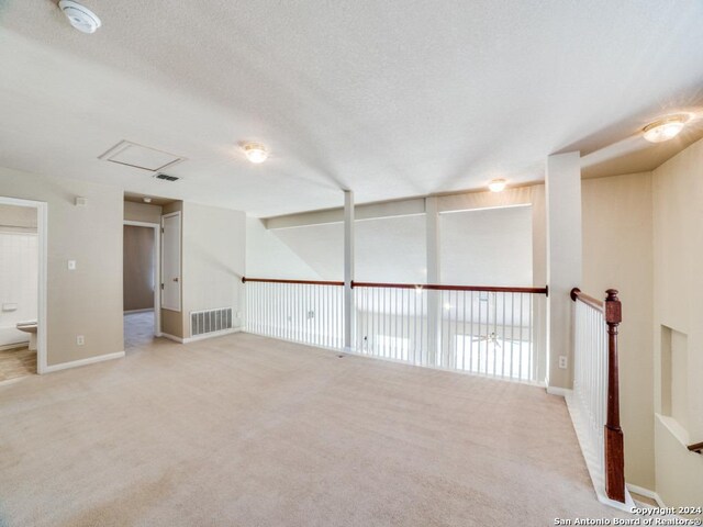 carpeted spare room featuring a textured ceiling