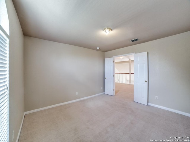 unfurnished bedroom with a spacious closet and light carpet