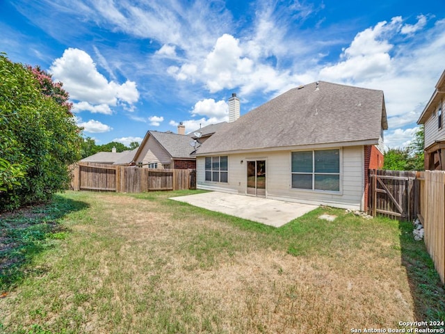 back of house with a patio and a lawn