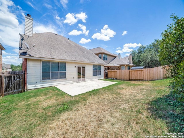 back of property with a lawn and a patio area