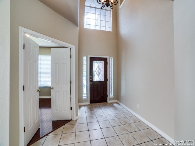 entryway with a notable chandelier and light tile patterned floors