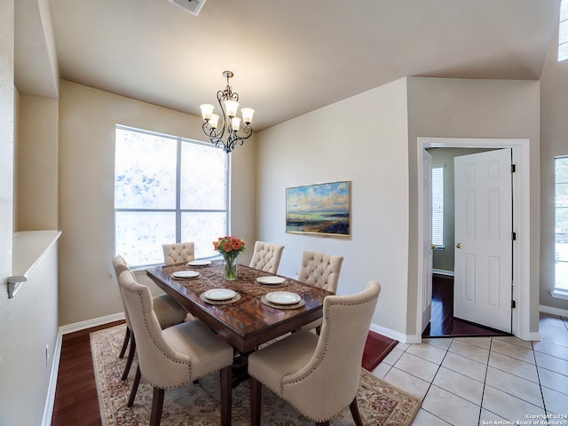 tiled dining room featuring a chandelier