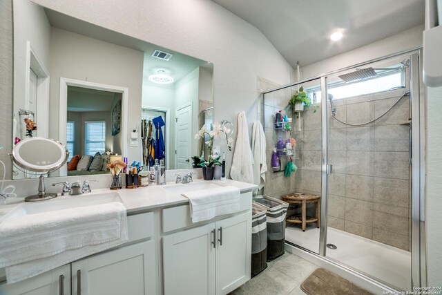 bathroom with plenty of natural light, double vanity, walk in shower, and tile patterned floors