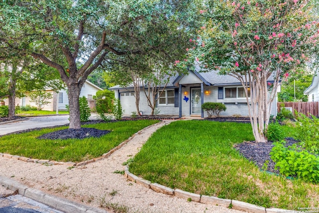 ranch-style house featuring driveway, brick siding, an attached garage, fence, and a front yard