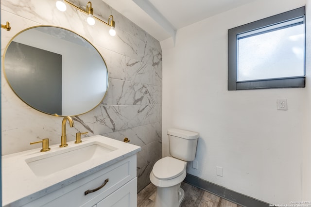 bathroom featuring wood-type flooring, tile walls, vanity, and toilet