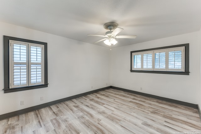 unfurnished room with light hardwood / wood-style flooring, ceiling fan, and a wealth of natural light