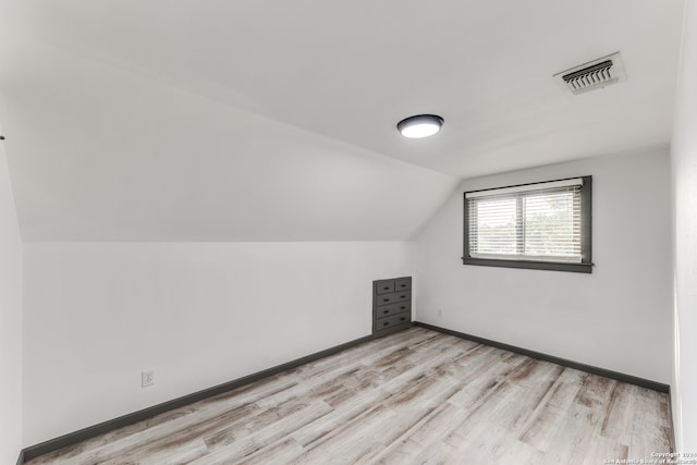 bonus room with light wood-type flooring and lofted ceiling