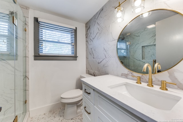 bathroom with a shower with shower door, vanity, toilet, and plenty of natural light