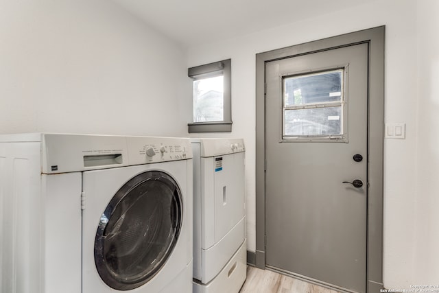 laundry area featuring washing machine and dryer and light wood-type flooring