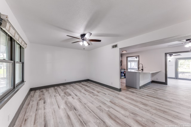 spare room featuring a textured ceiling, sink, ceiling fan, and light hardwood / wood-style floors