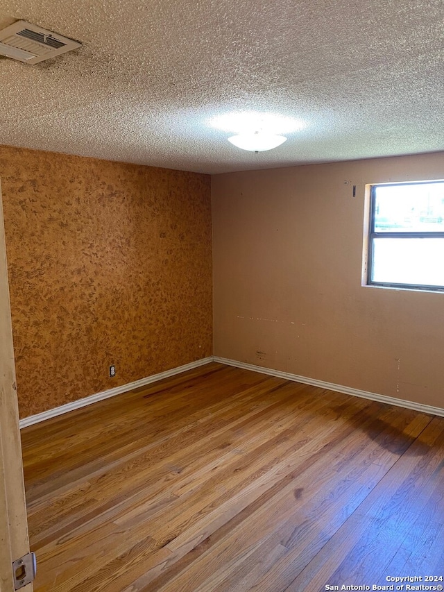 empty room featuring hardwood / wood-style floors and a textured ceiling