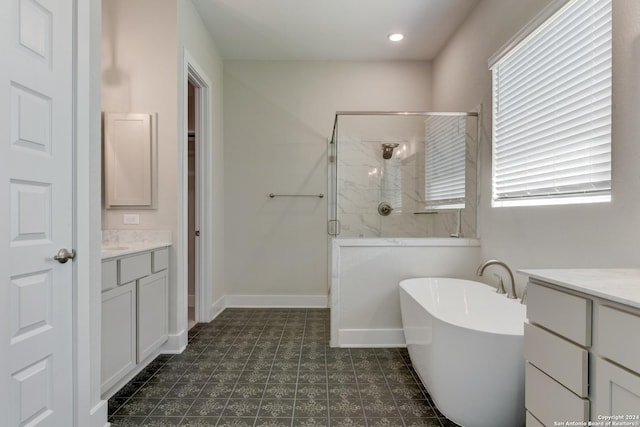 full bathroom featuring a freestanding bath, vanity, baseboards, and a stall shower