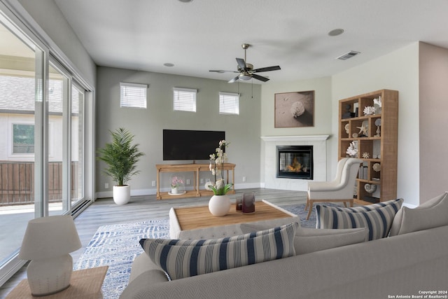 living area with plenty of natural light, ceiling fan, wood finished floors, and visible vents
