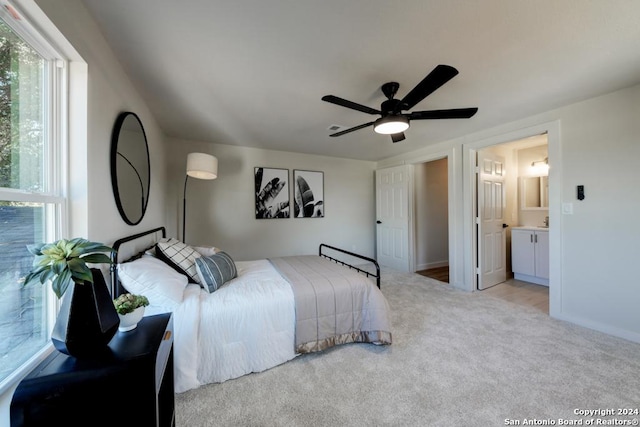 carpeted bedroom with ceiling fan and ensuite bath